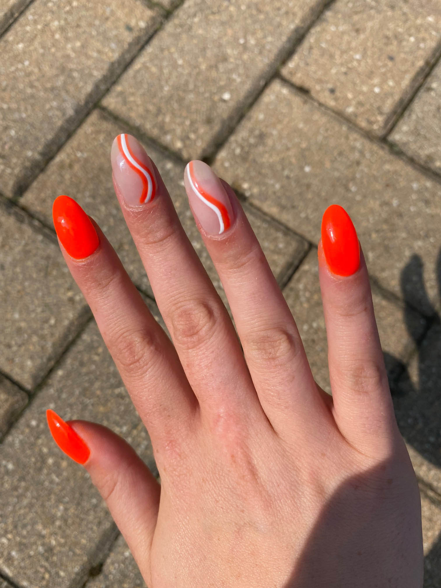 Bright Orange Nails With White Swirls Design Design