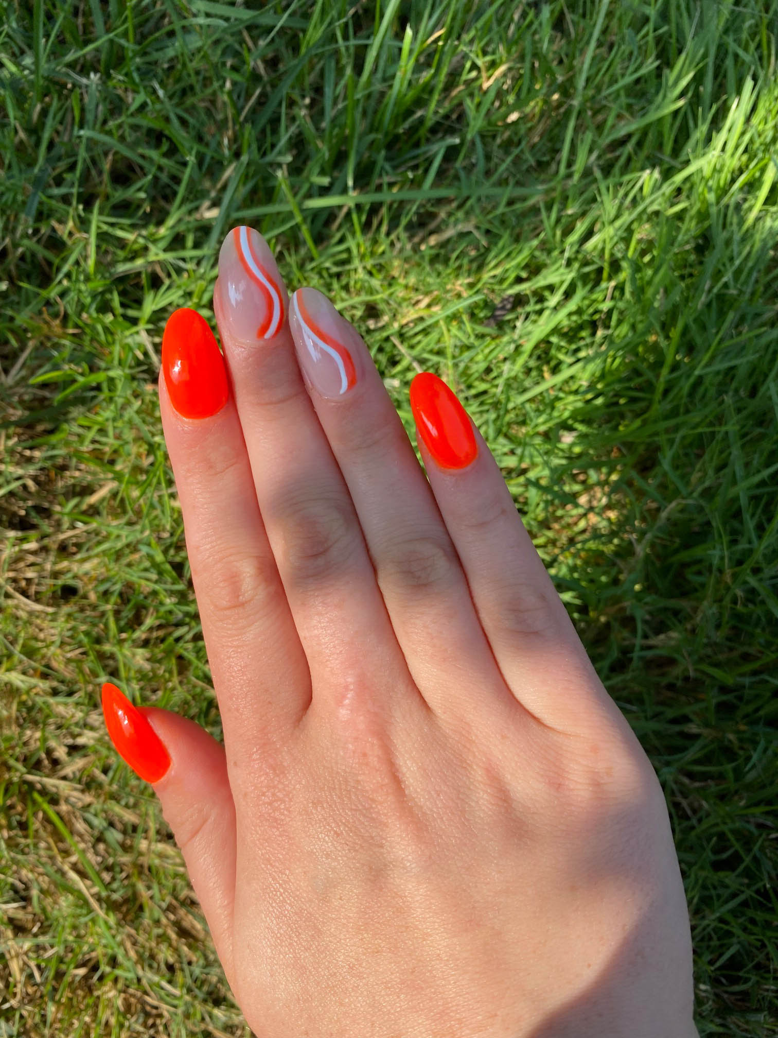 Bright Orange Nails With White Swirls Design Ideas