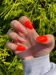 Bright Orange Nails With White Swirls Design Idea