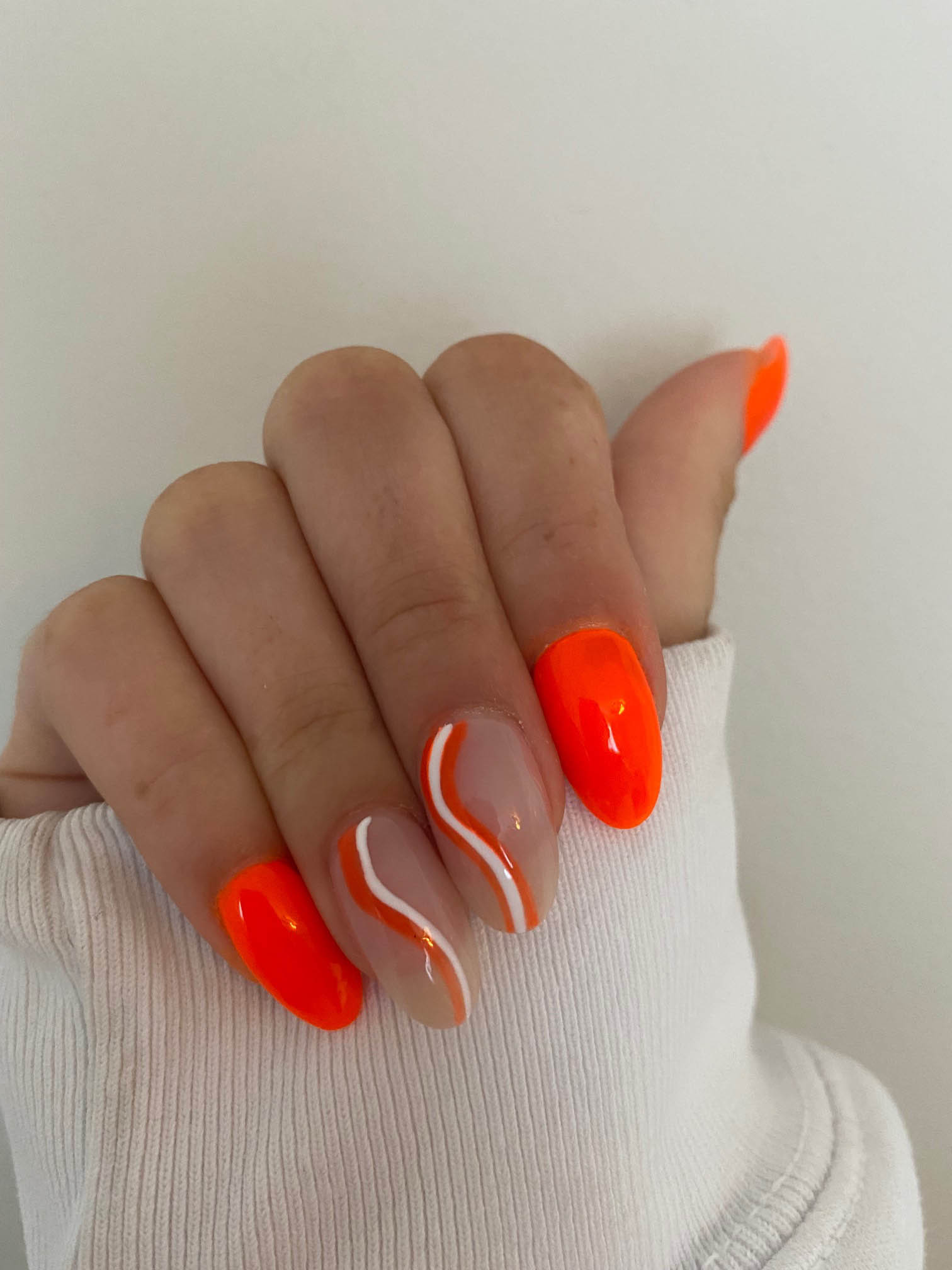 Bright Orange Nails With White Swirls Design